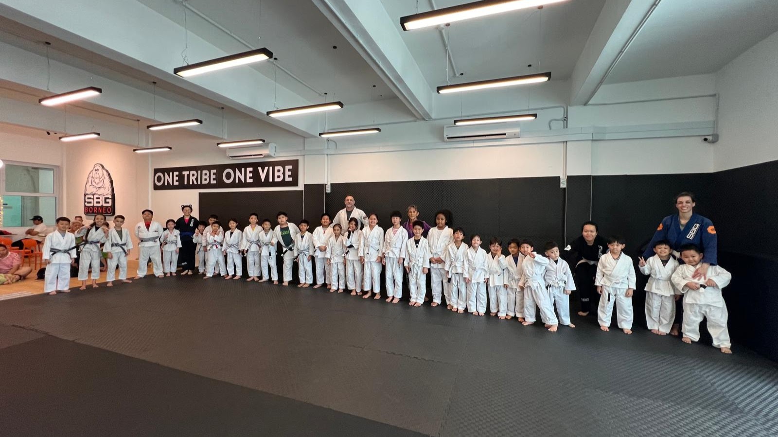 Children at SBG Borneo drilling a takedown, laughing mid-technique